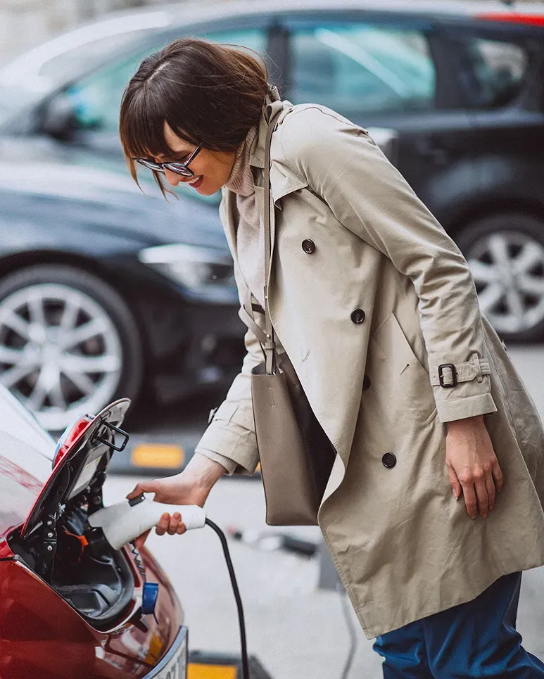 une femme rechargeant sa voiture électrique